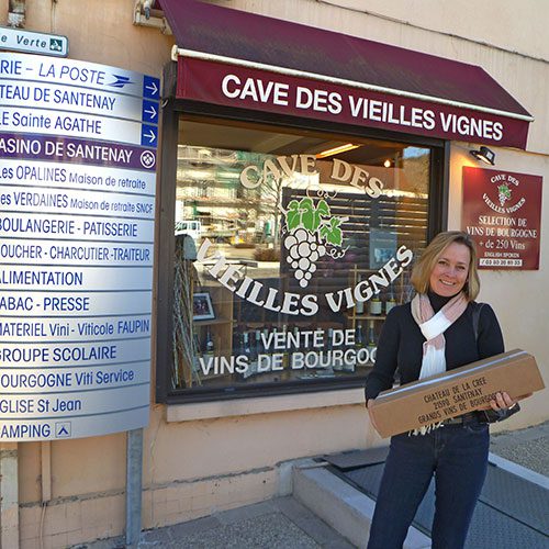 Lady holding package in front of wine store in Burgundy France